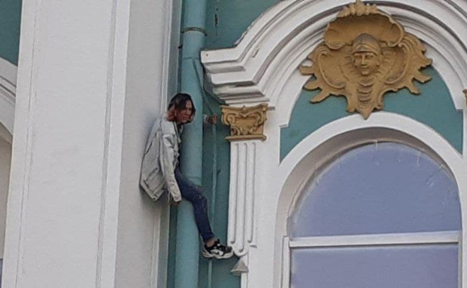 Молодой человек решил потренироваться в скалолазании на стене Эрмитажа